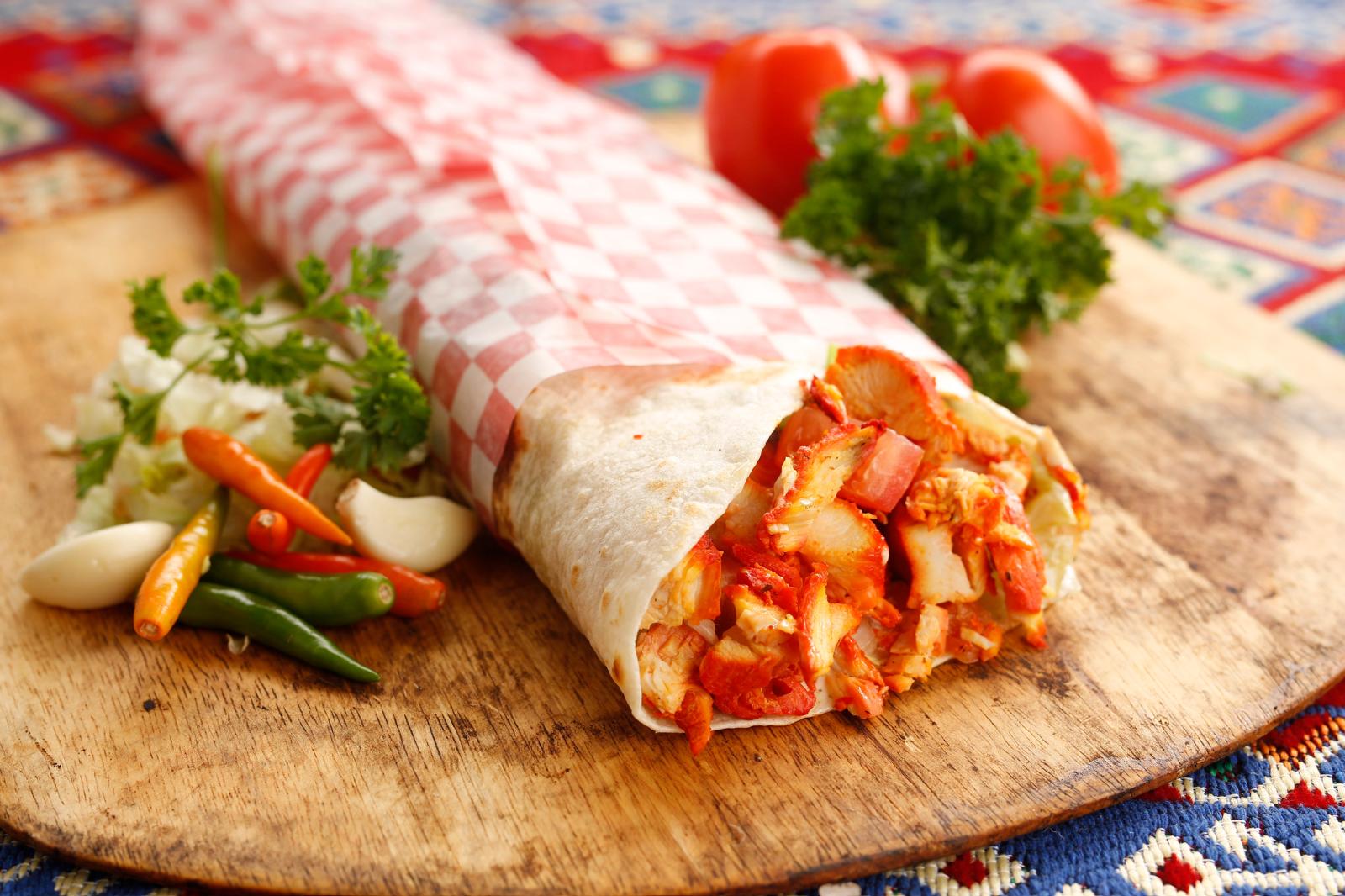 Donair wrap with spiced meat and fresh sides.